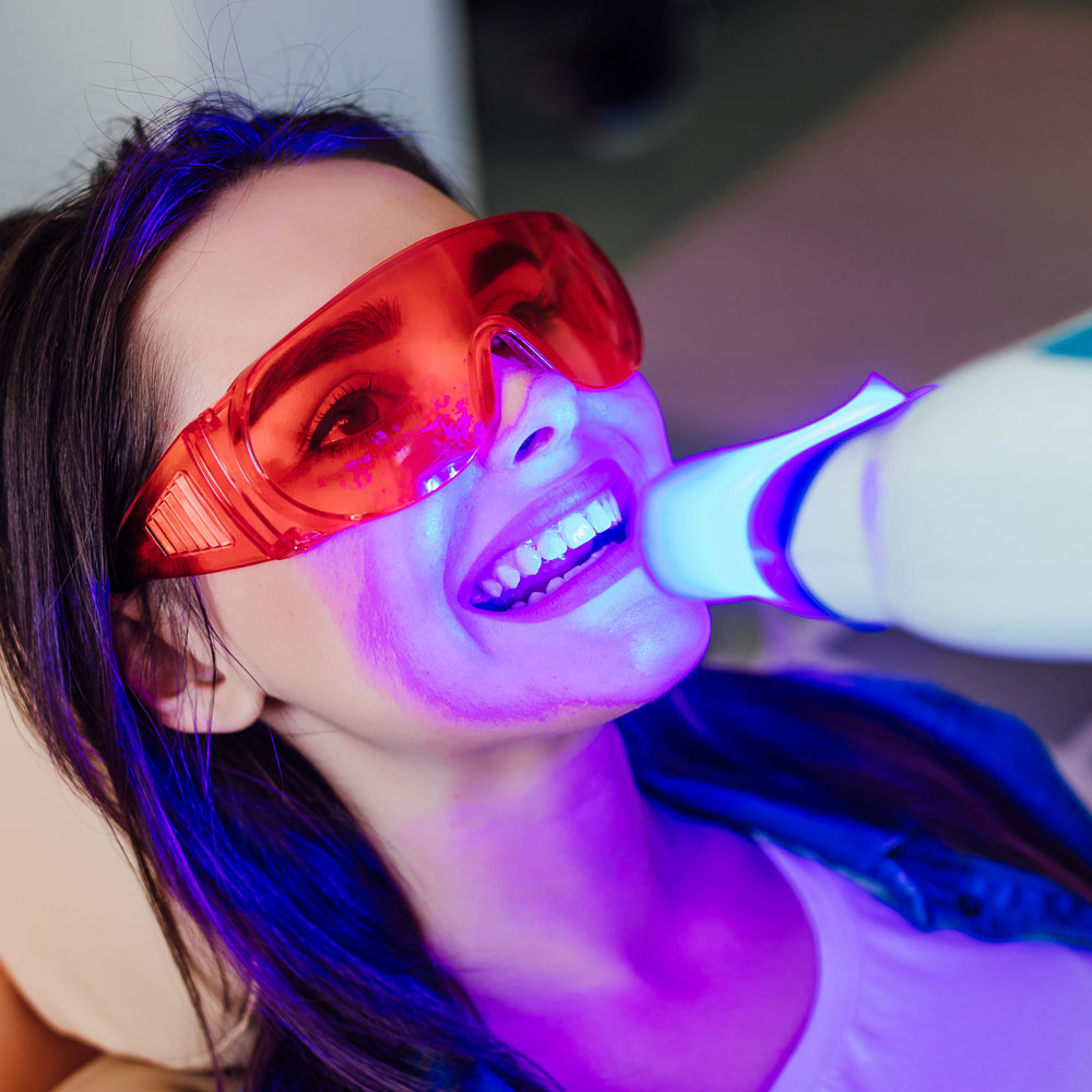 Patient wearing protective glasses during a UV dental treatment